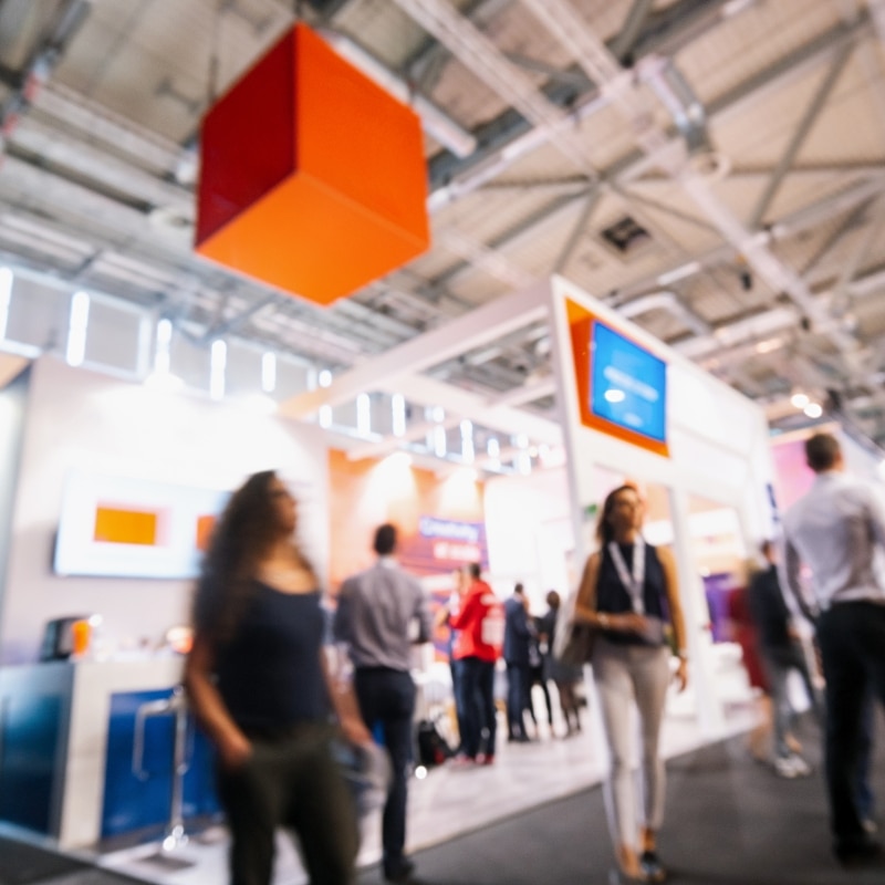 Visiteurs parcourant un salon professionnel avec stands et animations